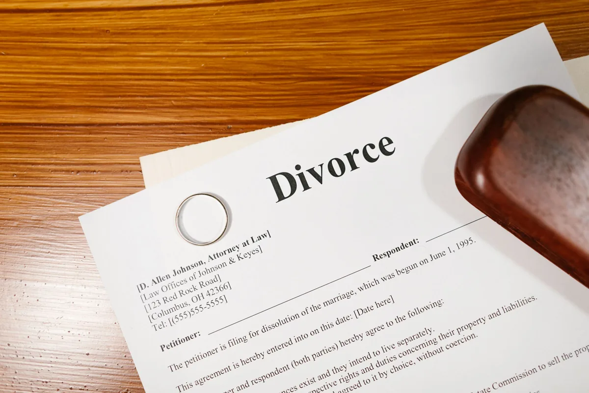 Documento de divorcio con una alianza sobre una mesa de madera